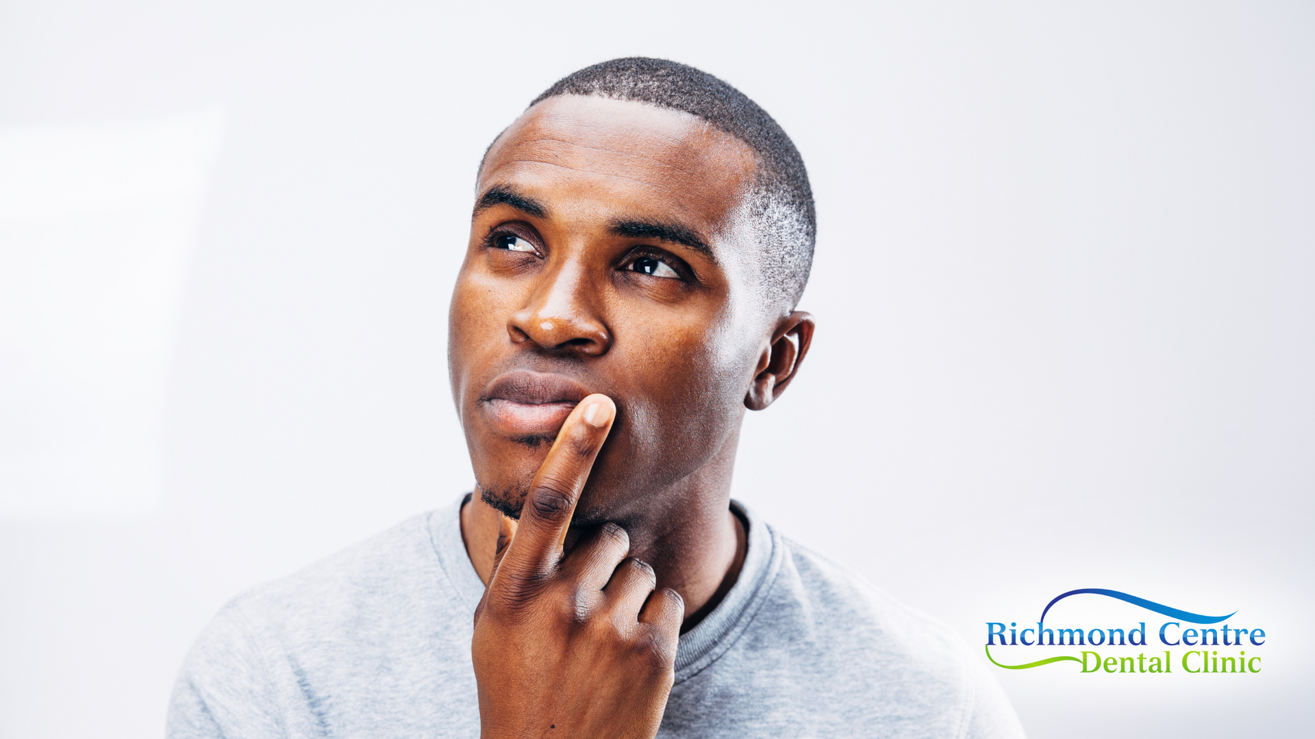 A man is thinking with his hand on his chin.